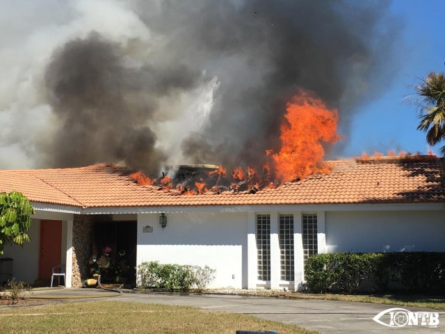 Firefighters battle the fire from the front door of the home in the Seminole Lake Golf And Country Club Estates